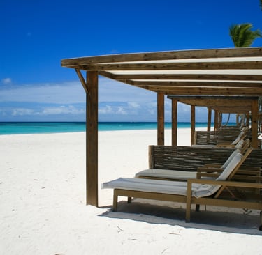 a beach with lounge chairs in cap cana