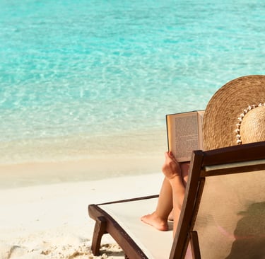 Woman reading on the beach in the Dominican Republic, best books to read on vacation