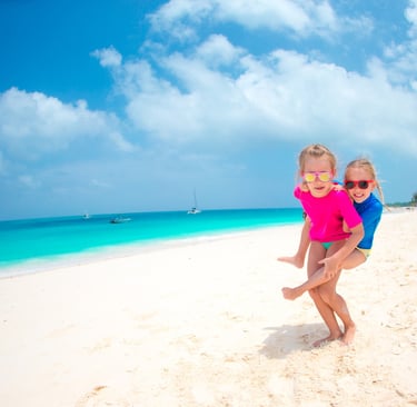 Two children playing on a white sand beach in the Dominican Republic