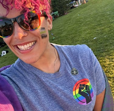 a woman with pink hair and sunglasses on a sunny day