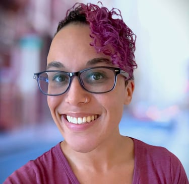 a woman with glasses and a purple shirt