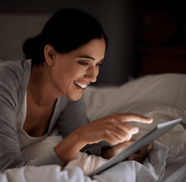 a woman is smiling and holding a tablet computer