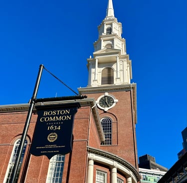 a church steeple with a sign saying Boston common in front