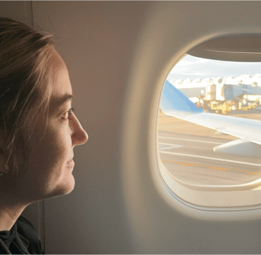 A lady looking out an airplane window
