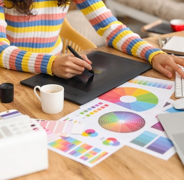 uma mulher sentada à mesa com um tablet e um copo de café
