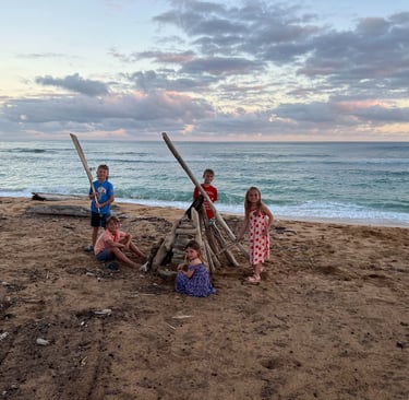 Kids building a fort on the beach in Kauai