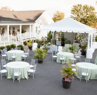 a large white tent with tables and chairs