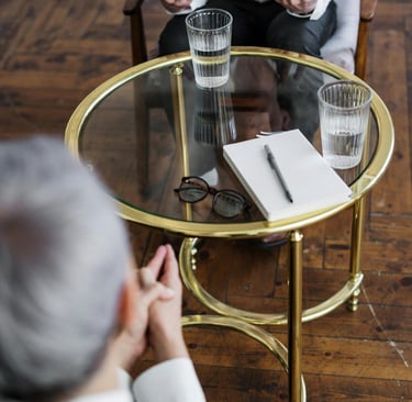 a man and woman sitting at a table with glasses