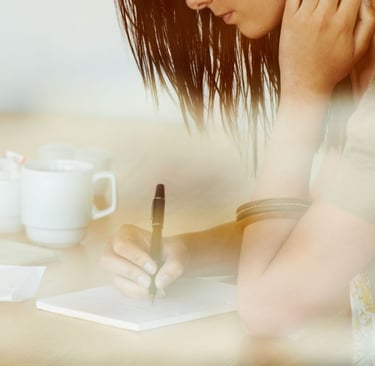  Woman journaling in a cozy space, practicing self-care.
