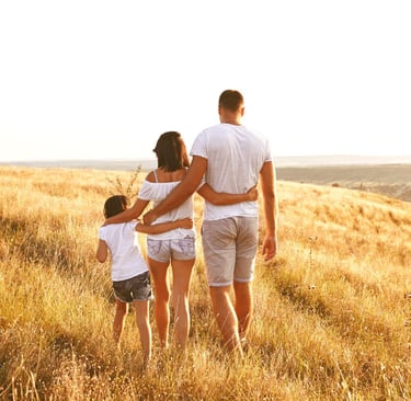 Happy family of three walking outdoors, enjoying nature together.