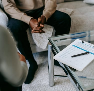 A calm therapy office setting in Calgary with an open notebook on a small table between two chairs,