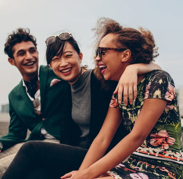 Three friends laughing. One of them is struggling with high functioning anxiety and masking symptoms