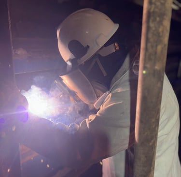 a man in a helmet welding a pipe into a pipe