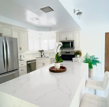 a kitchen with a large counter top and chairs