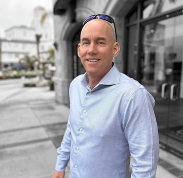 Carl Gregory in a blue shirt and sunglasses. Portrait-style photo.