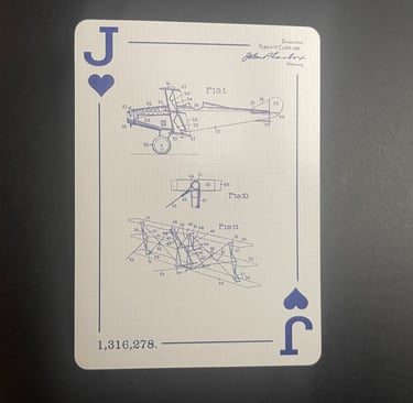 The Jack of Hearts facing up, displaying engineering drawings of a triplane from 1919