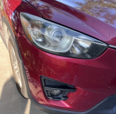 before image of shiny red car's headlight