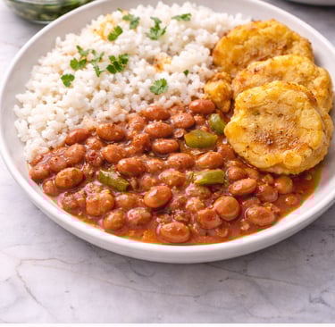 Puerto Rican habichuelas guisadas stewed red beans served with white rice and tostones on a plate