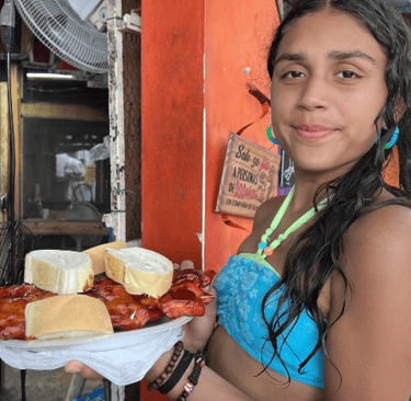 a girl holding a plate of Puerto Rican pinchos