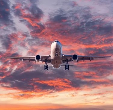 a plane taking off into the sunset