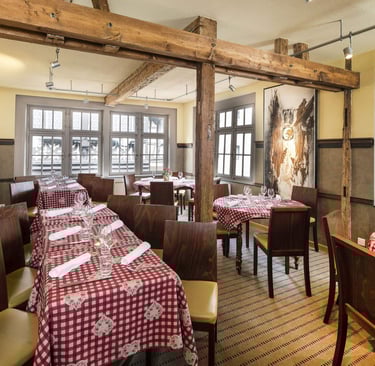 a restaurant with tables and chairs and a table with a red table cloth