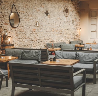 a restaurant with a stone wall and a table with chairs