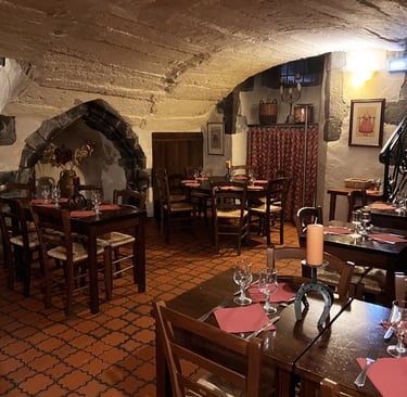a restaurant with a stone wall and a table with wine glasses