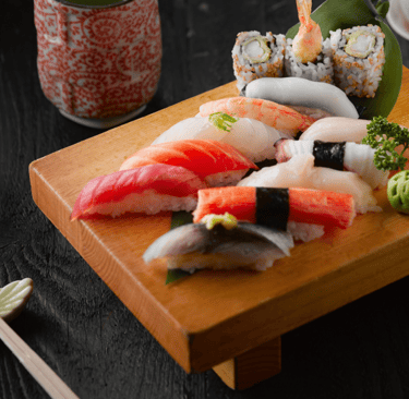 a wooden cutting board with sushi and chopsticks