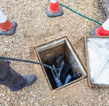A plumber unblocking a sewage drain using camera inspection.