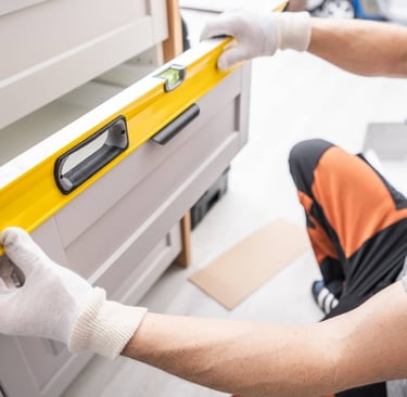 Cabinet installer leveling drawers and adjusting.