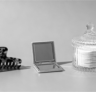 A minimalist set of daily essentials: hair clips, pocket mirror, and cotton pads.
