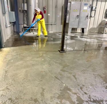 CLEANING SPECIALIST DEEP CLEANS THE FLOOR AT AN INDUSTRIAL FACILITY