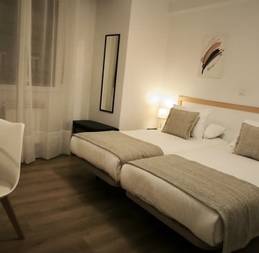 Camas gemelas en habitación con salón - Hotel Arias 