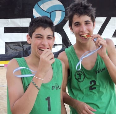 two boys are holding their medals in front of a banner