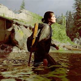 a woman in a raincoat and a backpacker in the water
