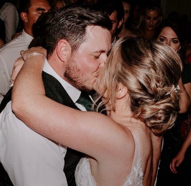 a bride and groom kissing on the dance floor