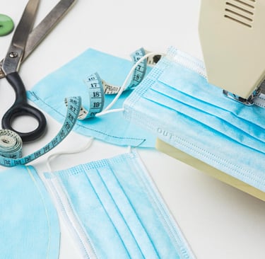 sewing-machine-stitching-medicated-masks-scissors-lying-on-table
