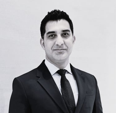 Black and white photo of a professional man wearing suit blue pen education consulting