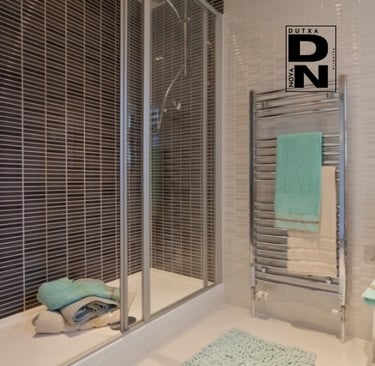 Ducha con mampara de cristal y azulejos decorativos oscuros, estilo elegante y moderno en baño reformado por Dutxa Nova en Va