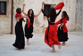 Women dancing pizzica folk dance with tambourine during festival in Salento Puglia