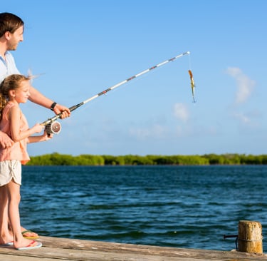 Father And daughter fishing from dock