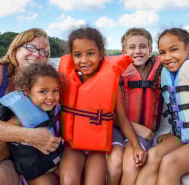Family riding on boat in life jackets