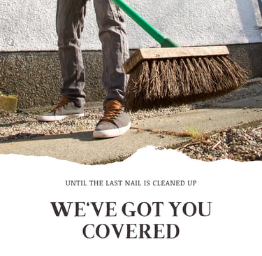 A worker sweeping up a job site at the end of a job in jeans and sneakers