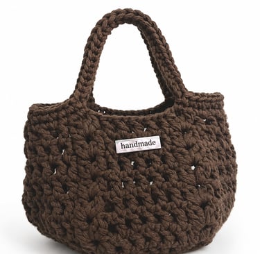Custom metal logo label attached to a handmade crochet handbag