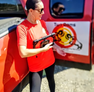 a woman in a red shirt is holding a gun