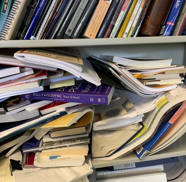 Books piled haphazardly on shelf