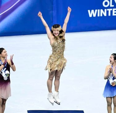 Alysa Liu jumping with both arms overhead on Olympic podium