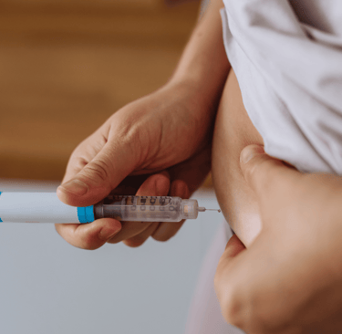 Woman administering IVF hormone injection in lower abdomen