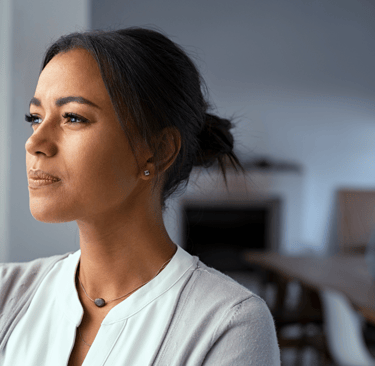 Pensive woman looking out the window, contemplating fertility journey