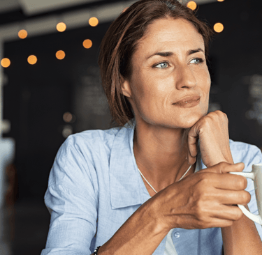 Woman sipping coffee and reflecting on fertility journey
